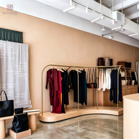 Porte-vêtements en métal doré incurvé avec base en bois clair, support de présentation pour vêtements, présentoir pour boutique de vêtements, pour magasin de vente au détail