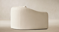 Fauteuil artisanal Los Angeles, expression sculpturale, dossier arrondi, accoudoirs inclinés avec finitions, coussins en duvet et plumes moelleux