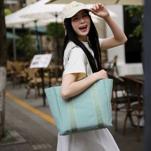 กระเป๋าโท้ทสีพื้นเรียบง่าย กระเป๋าถือสตรีพิมพ์โลโก้ได้ น้ำหนักเบา เหมาะสำหรับเดินทาง ท่องเที่ยว ช้อปปิ้ง ทำจากผ้าแคนวาส - Product Image 1