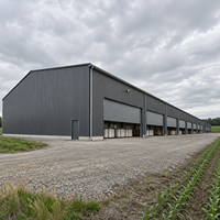 Entrepôt en structure métallique résistante aux intempéries, grande porte coulissante, atelier métallique durable, stockage d'équipements, bâtiment agricole