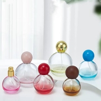 Flacon de parfum en verre transparent à dégradé de couleurs, avec bouchons décoratifs en forme de sphère en plastique, métal ou bois multicolores