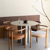 Table à manger minimaliste de style italien en acier inoxydable, modèle inspiré des designers, luxe discret, pieds à trois colonnes, ambiance haut de gamme