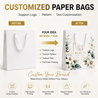 Sac en papier cadeau blanc de luxe recyclable en gros d'usine avec nœud en ruban noir et logo personnalisé pour l'emballage de vêtements et d'artisanat de détail