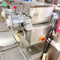 Machine à encruster à décharge automatique pour la production de pâtisseries fourrées