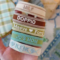 Pulseras al por mayor personalizadas con logo y texto, estilo bohemio, con cinta, letras bordadas, borlas y tejido religioso.