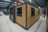 Conteneur extensible de 20 pieds avec cadre gris et grain de bois clair, moderne, étanche, solution de construction préfabriquée industrielle en vrac