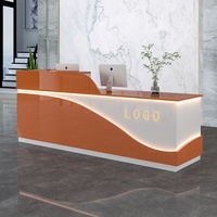 Bureau d'accueil moderne bicolore en forme de L, orange et blanc, avec bande lumineuse LED, comptoir de réception brillant pour hôtel, bureau, hall d'entrée
