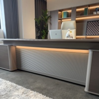 Bureau de direction en L de luxe, finition bois chaud, panneau LED à lattes diagonales, prise intégrée pour suite de bureau complète