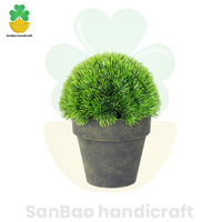 Une belle plante artificielle en pot en forme de boule de pin