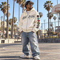 Sweat à capuche oversize crème zippé avec imprimé graphique sur la poitrine, patchs brodés sur les manches, épaules tombantes, style streetwear, personnalisable, vente en gros