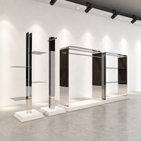 Vitrine de présentation de vêtements en acier inoxydable miroir avec dessus arrondi, tringle de suspension et socle blanc sur mesure