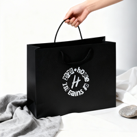 Sac en papier kraft noir épais de qualité supérieure avec poignées en corde ronde, design durable et élégant, idéal pour la vente au détail de luxe, l'emballage de cadeaux