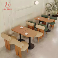 Ensemble de mobilier de restaurant commercial moderne avec tables rondes en bois brun, chaises en bois, banquette en cuir vert pour café