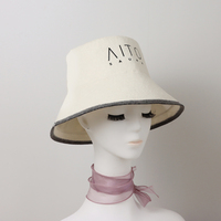 Un gorro de sauna de lana pura color crema que convierte la lambda griega en un distintivo de marca y convierte cada sala de vapor en una declaración de diseño.