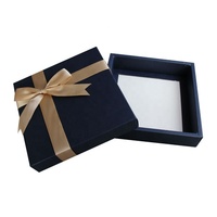 Boîte à bonbons et chocolats en carton rigide avec insert en plastique, ornée de nœuds en ruban à bord doré, pré-noués, en satin élastique, et de décorations.