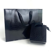 Sac en papier noir personnalisable avec motifs lézards et crocodiles, film brillant, sac cadeau haut de gamme et tendance pour magasin de vêtements