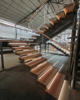 Escalier flottant droit avec poutre centrale, marches en bois et garde-corps en verre sans cadre