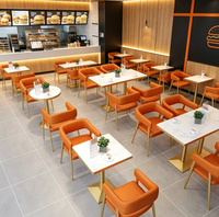 Kürbisorange Gepolsterte Esszimmerstühle Set Marmortischplatte Goldene Tischgestelle und Sitzbänke für Cafeteria Hotel Geschäft