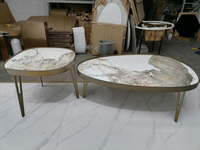 Table basse ovale gain de place en pierre frittée de haute qualité avec structure en métal doré pour maison contemporaine