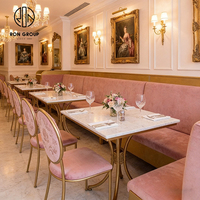 Elegante Franse roze fluwelen bankzittingen met gouden frame, tafel en stoelen van gesinterd steen, meubelset voor koffieshop en restaurant