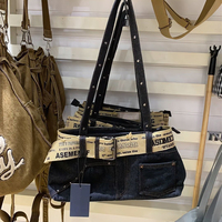 Sac fourre-tout à bandoulière grande capacité en denim délavé foncé avec sangle réglable, poche avant renforcée à rivets et sangle en toile à lettres, idéal pour les trajets quotidiens