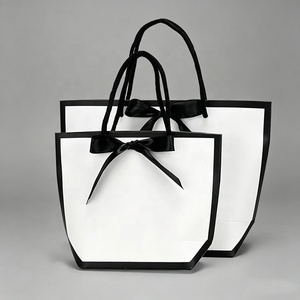Sacs cadeaux trapézoïdaux élégants noirs et blancs en papier d'art de luxe avec nœud en satin pour boutiques, mariages, cosmétiques et vêtements - En stock et prêts à l'emploi - Product Image 1