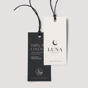 ป้ายแขวนเสื้อผ้ากระดาษแข็งแบบกำหนดเอง เป็นมิตรกับสิ่งแวดล้อมและรีไซเคิลได้ ขายส่งป้ายกระดาษสำหรับเสื้อผ้าพร้อมโลโก้ เหมาะสำหรับชุดลำลองและเครื่องแต่งกาย - Product Image 1