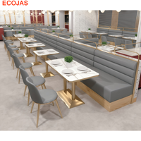 Banquette de restaurant longue avec assise rembourrée grise, tables blanches et chaises de salle à manger