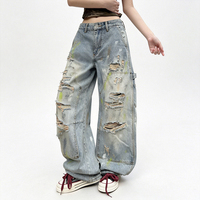 Jean long en denim style rétro américain, coupe courbée, effet vieilli et déchiré avec trous, peint avec des graffitis colorés