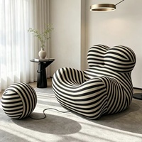Fauteuil de salon sculptural en mousse moulée monobloc, design enveloppant, avec ottoman en tissu rayé