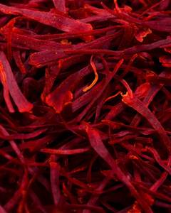 Fleur de crocus violette avec fils de safran rouge sur surface en bois - Product Image 1