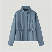 Veste coupe-vent légère et décontractée pour femme avec col montant, taille à cordon de serrage, patte de boutonnage cachée et coupe courte
