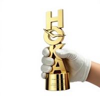 Trophée commémoratif créatif personnalisé en alliage avec design de poupée de dessin animé plaqué or, fabriqué au Guangdong