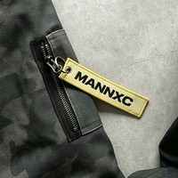 Blouson bomber à capuche camouflage personnalisé avec logo, fermeture éclair, broderie, patch imprimé, coupe oversize, style streetwear, avec poche zippée et étiquette pour homme
