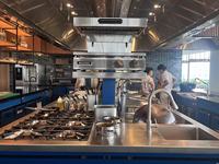 Cuisine îlot sur mesure avec armoire vapeur, gril et friteuse pour les services de restauration des salons VIP des aéroports