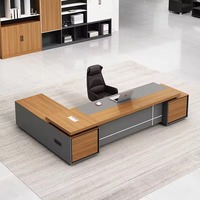Bureau de direction en forme de L, plateau gris foncé mat, panneau frontal en bois avec ports d'alimentation, bureau moderne