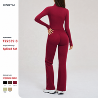 Ensemble de sport pour femme à col montant et fermeture éclair intégrale, comprenant une veste courte à coutures effet corset et un pantalon évasé coupe bootcut, avec poches latérales et passe-pouces, en matière effet seconde peau, vêtements de sport
