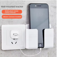 Support mural pour téléphone portable multifonctionnel populaire, nouveau, adhésif, support de chargeur mobile avec télécommande, support mural en plastique