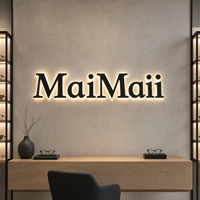 Enseigne de magasin d'optique : Lettres rétroéclairées en acier inoxydable noir mat avec halo acrylique chaud pour mur de showroom de lunettes haut de gamme