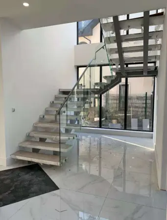 Escalier droit flottant Escalier central à colonne vertébrale Escalier à limon moyen avec bande de roulement en bois et garde-corps en verre sans cadre