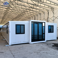 Maison modulaire en conteneur blanche fabriquée en usine avec cadre noir, porte double en verre, plusieurs fenêtres, maison préfabriquée portable