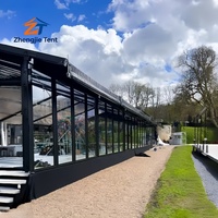 Tente de mariage de luxe avec cadre noir en verre, pavillon transparent pour fêtes en plein air, réceptions et événements de célébration