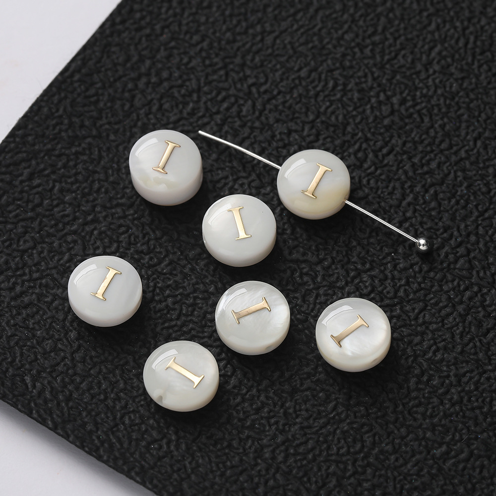 Perles de lettres en coquillages -- I