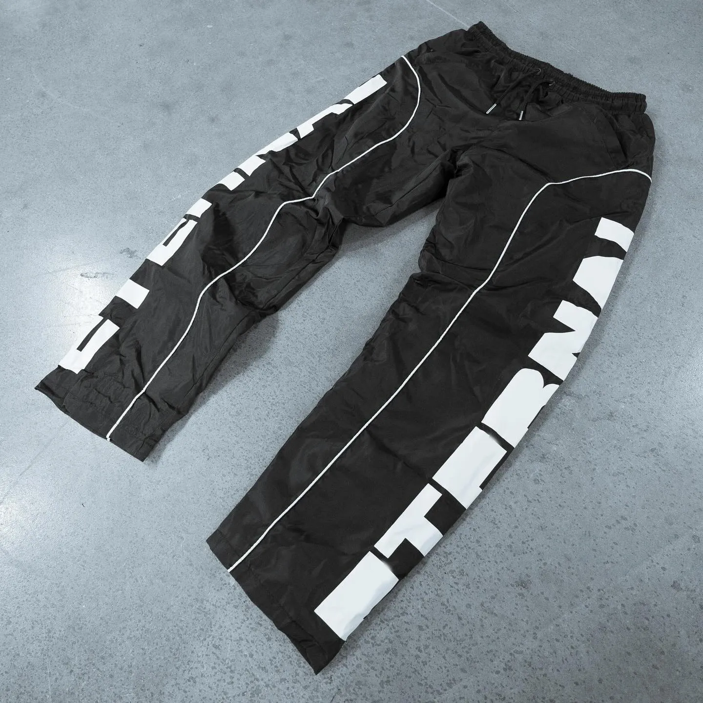 पुरुषों के नायलॉन के लिए कस्टम उच्च गुणवत्ता वाले स्पोर्ट्स रनिंग ओवरसाइज़्ड बैगी प्रिंट ट्रैक पैंट रिफ्लेक्टिव विंडब्रेकर पैंट