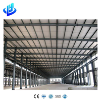 Almacén de estructura de acero de gran capacidad con vigas Q355B y muro cortina para almacenamiento de maquinaria pesada