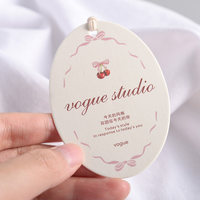 Étiquette suspendue ovale avec illustration nœud cerise, cordon en coton rose coquette, pour vêtements romantiques style 'Sweet Girl'