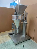 Sac de bouteille pour lait cosmétique, petite machine de remplissage semi-automatique, devant de table, sachet sec de produits chimiques, pesage de la poudre benne, poterie, lot de