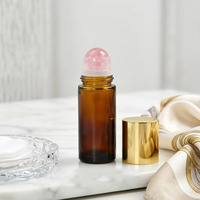 Flacon roll-on cylindrique en verre ambré de 10 ml avec pierre précieuse de quartz rose naturel et bouchon doré – Protection UV de luxe pour l'aromathérapie