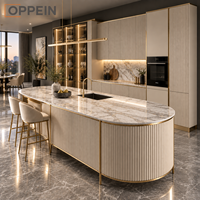 Îlot de cuisine moderne et luxueux sur mesure OPPEIN, armoire à panneaux cannelés beige avec éclairage LED pour projet de villa