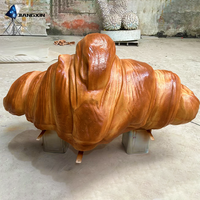 Sculpture de canapé en forme de croissant - Siège en fibre de verre inspiré de la boulangerie avec texture de croûte dorée pour les terrasses de cafés et les espaces commerciaux